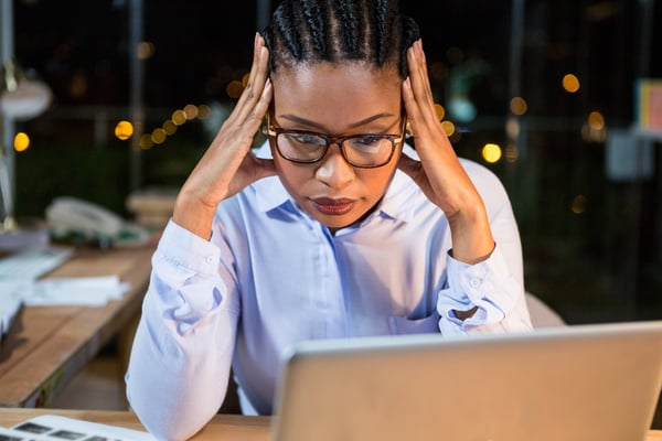 Mulher de negócios estressada sentada em sua mesa no escritório-1